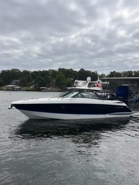 Slide: The Image of 2019 Cobalt A40 boat on a lake with cloudy skies and shoreline in the background. - 1