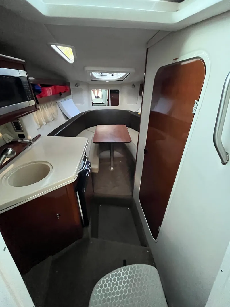 Slide: The Image of 2014 Sea Ray 260 Sundancer cabin interior with kitchenette and seating area. - 10