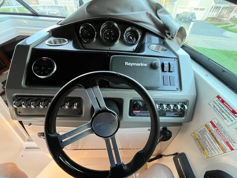 Slide: The Image of 2014 Sea Ray 260 Sundancer dashboard with steering wheel and Raymarine controls. - 16