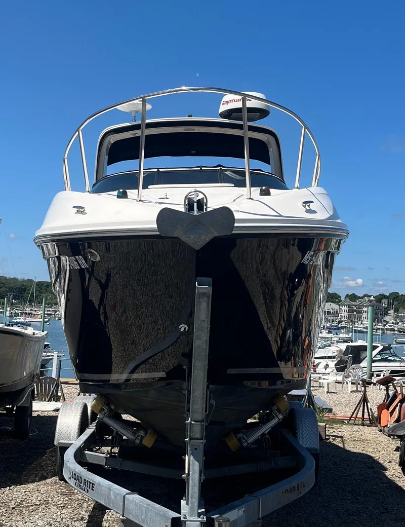Slide: The Image of 2014 Sea Ray 260 Sundancer boat on trailer, marina background, clear blue sky. - 2