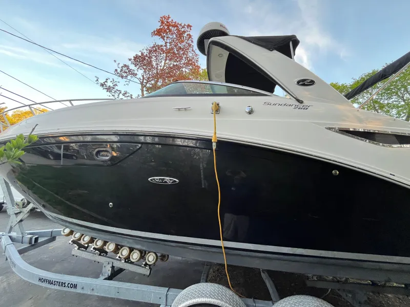 Slide: The Image of 2014 Sea Ray 260 Sundancer boat on trailer, side view with trees in background. - 38
