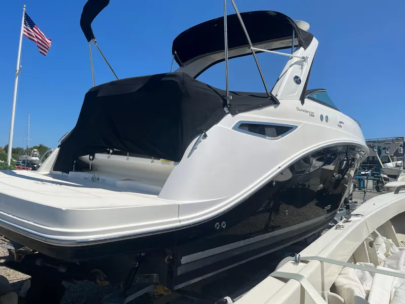Slide: The Image of 2014 Sea Ray 260 Sundancer boat on trailer, American flag in background, sunny day. - 4