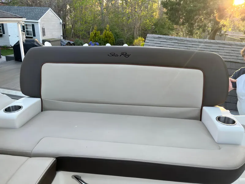 Slide: The Image of 2014 Sea Ray 260 Sundancer boat seat with cup holders, outdoor setting. - 9