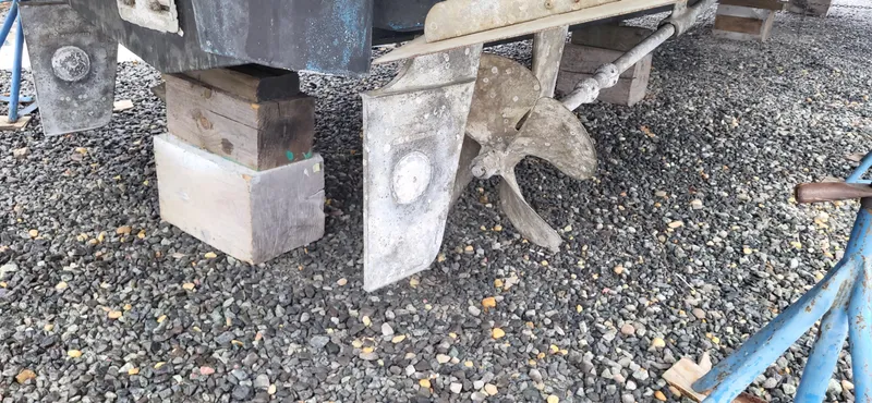 Slide: The Image of 2007 Silverton 43 Motor Yacht propeller and rudder on gravel, supported by blocks. - 11