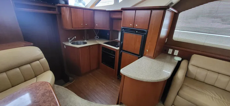 Slide: The Image of Interior of 2007 Silverton 43 Motor Yacht with wood cabinetry and beige seating. - 18