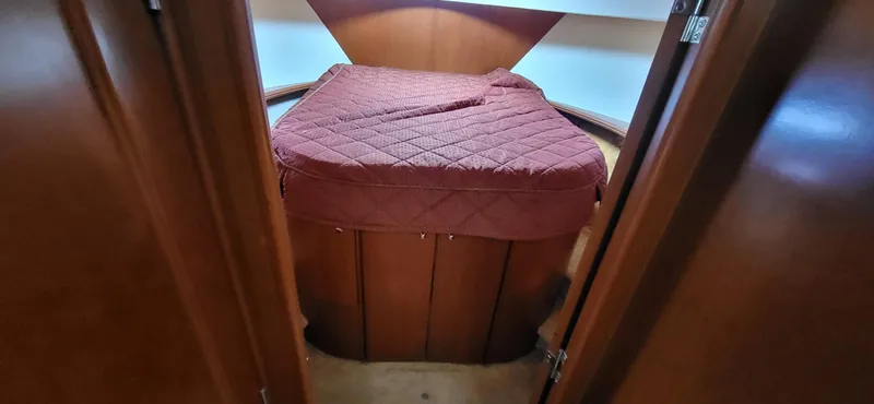 Slide: The Image of 2007 Silverton 43 Motor Yacht cabin with red bedding and wooden interior. - 4