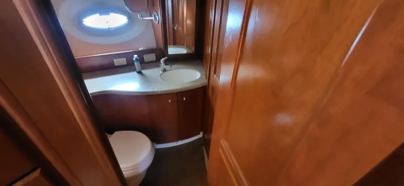 Slide: The Image of 2007 Silverton 43 Motor Yacht bathroom with wooden cabinetry and oval window. - 5