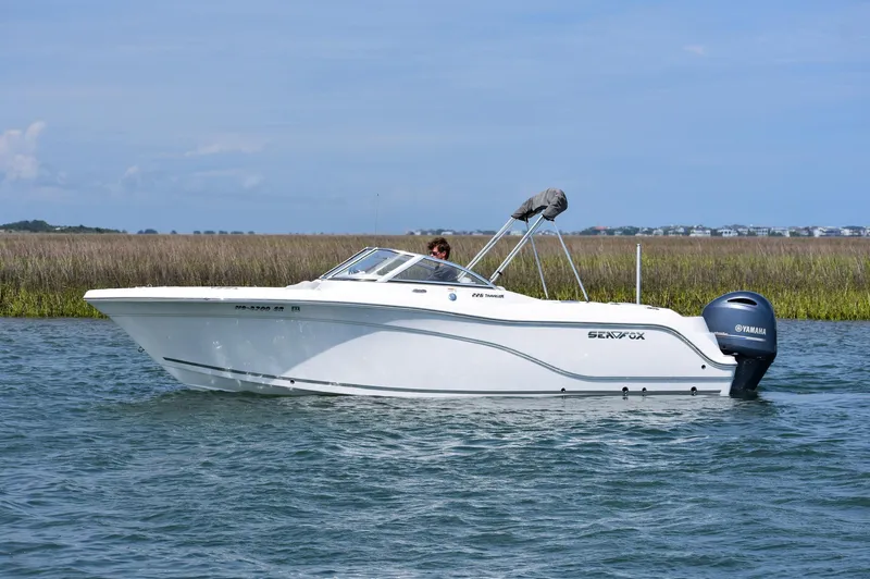 Slide: The Image of 2020 Sea Fox 226 Traveler boat cruising on calm water with scenic marshland backdrop. - 2