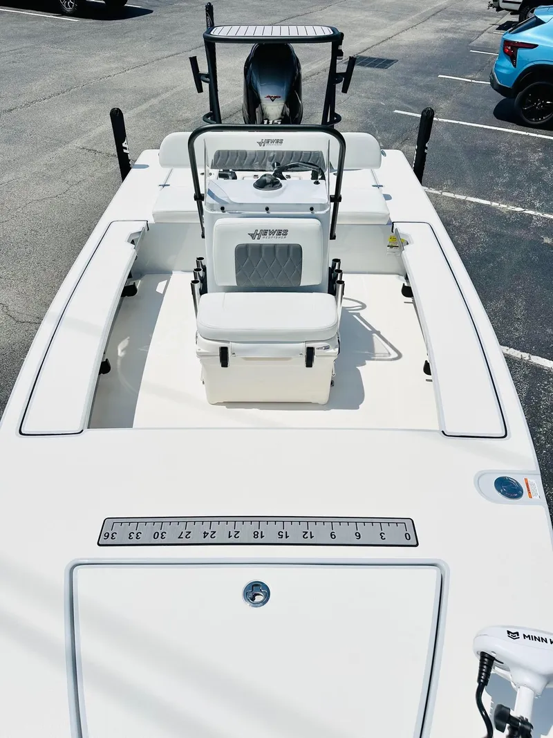 Slide: The Image of 2022 Hewes Redfisher 18 boat with white deck and seating, parked in a lot. - 12