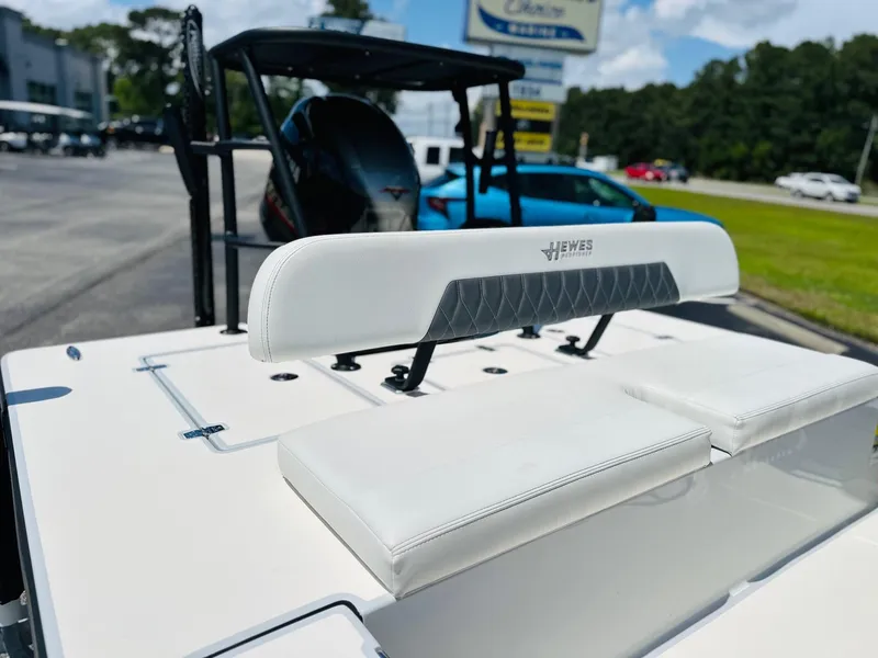 Slide: The Image of 2022 Hewes Redfisher 18 boat with white seating, parked outdoors. - 13