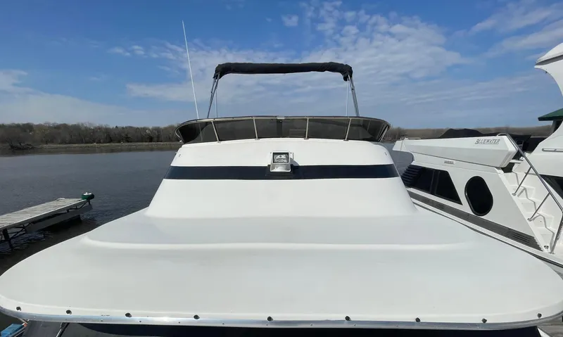 Slide: The Image of 1984 Bluewater 42 Coastal Cruiser docked on a calm river under a clear sky. - 11