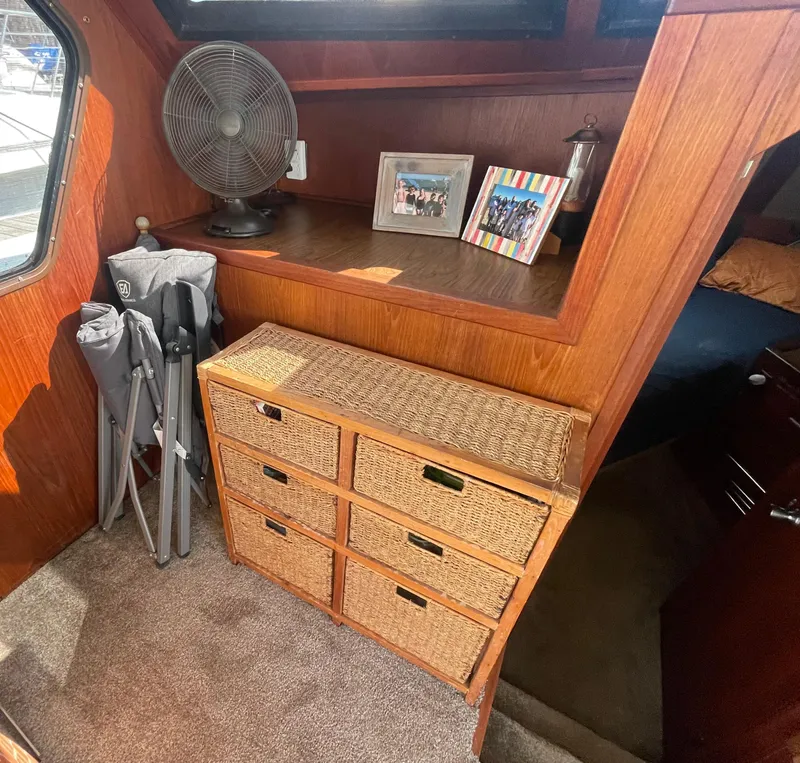 Slide: The Image of Interior of 1984 Bluewater 42 Coastal Cruiser with wicker drawers and framed photos. - 24