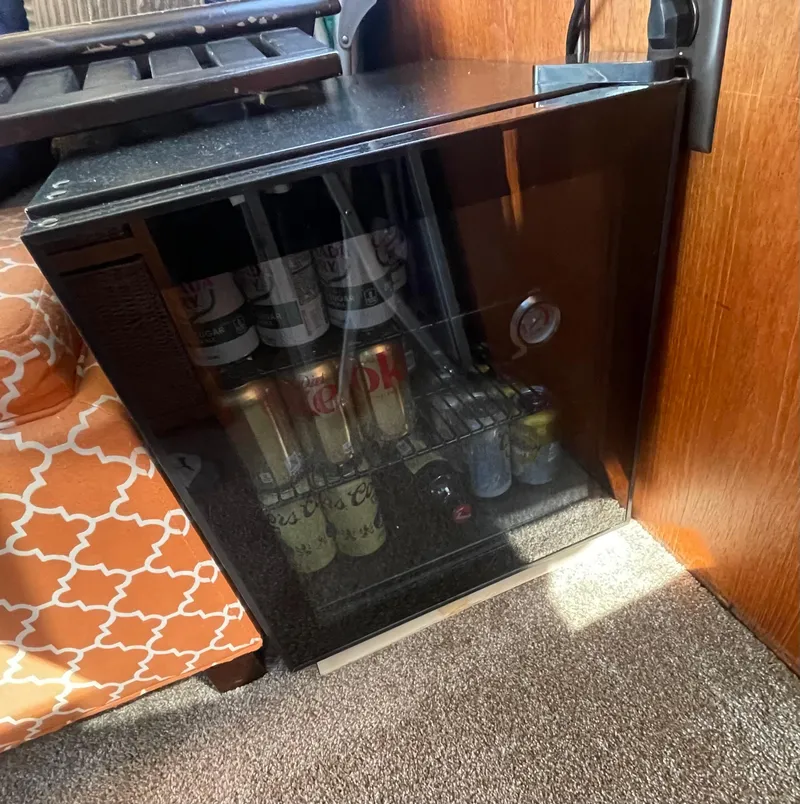 Slide: The Image of Mini fridge stocked with beverages inside a 1984 Bluewater 42 Coastal Cruiser. - 25