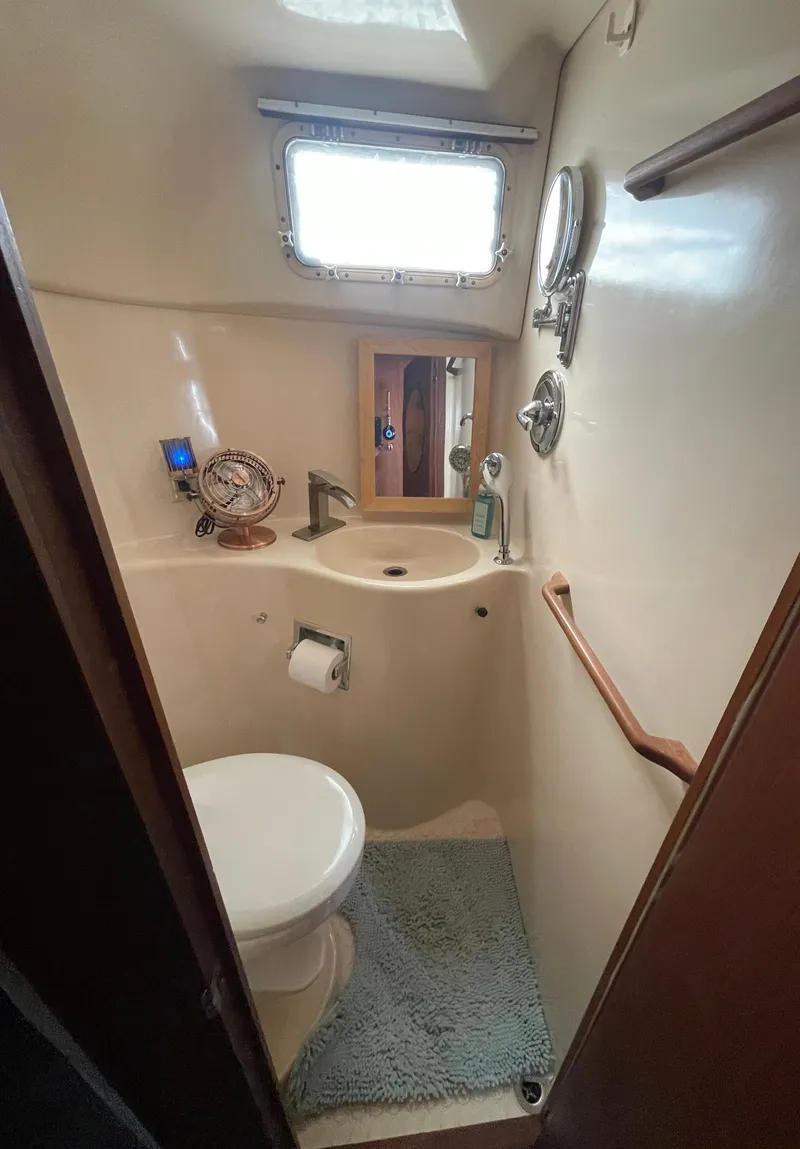 Slide: The Image of 1984 Bluewater 42 Coastal Cruiser bathroom with toilet, sink, and window. - 33