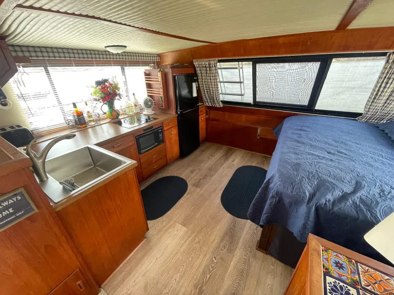Slide: The Image of 1984 Bluewater 42 Coastal Cruiser interior with kitchen, bed, and wood accents. - 34
