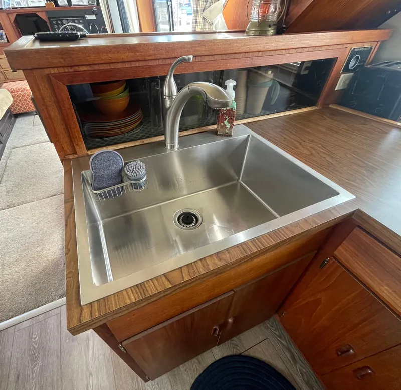 Slide: The Image of 1984 Bluewater 42 Coastal Cruiser kitchen sink with wooden cabinetry and stainless steel fixtures. - 37