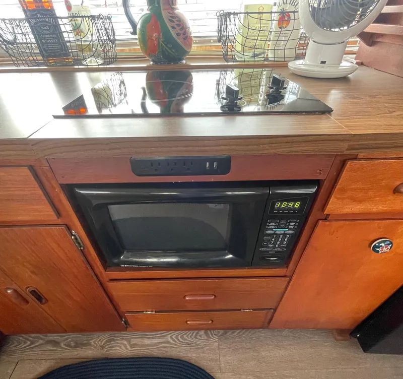 Slide: The Image of 1984 Bluewater 42 Coastal Cruiser kitchen with microwave and stovetop. - 38