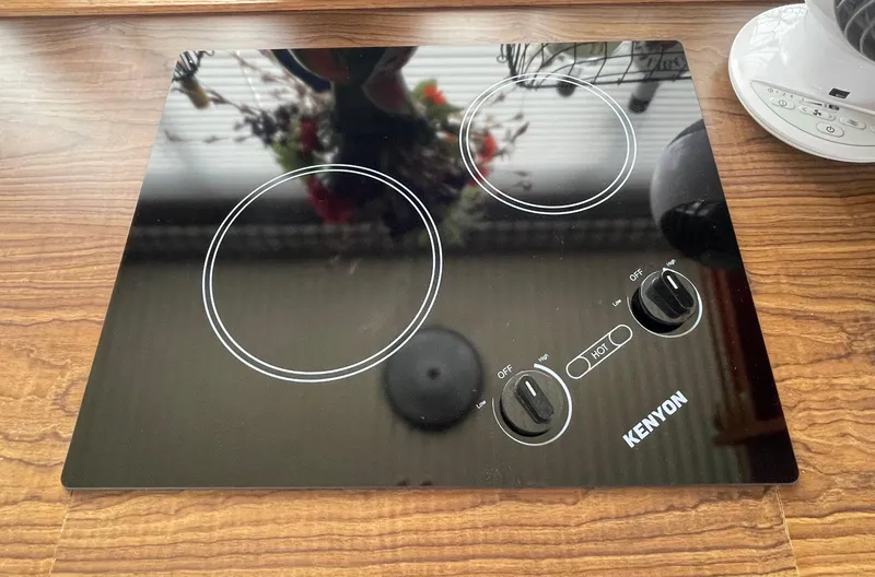Slide: The Image of Kenyon electric cooktop on Bluewater 42 Coastal Cruiser, 1984 model, with two burners and control knobs. - 44
