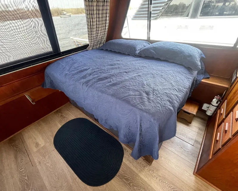 Slide: The Image of Cozy bedroom in 1984 Bluewater 42 Coastal Cruiser with blue bedding and wood accents. - 45