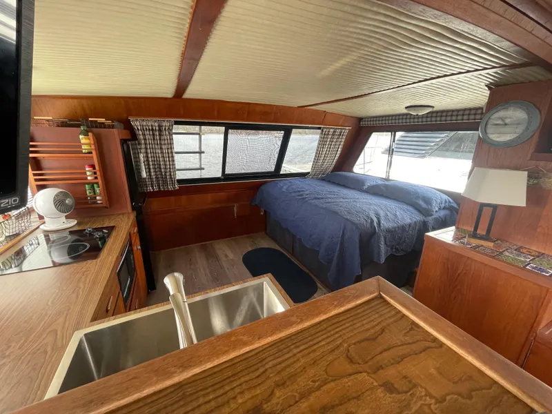 Slide: The Image of 1984 Bluewater 42 Coastal Cruiser interior with bed, kitchenette, and wood finish. - 48