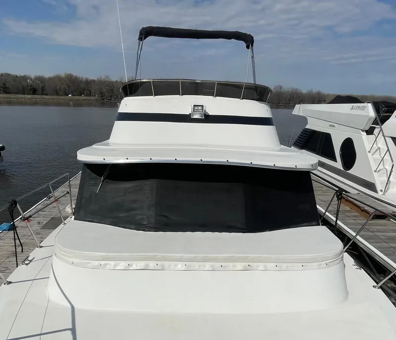 Slide: The Image of 1984 Bluewater 42 Coastal Cruiser docked on a calm river under a clear sky. - 9