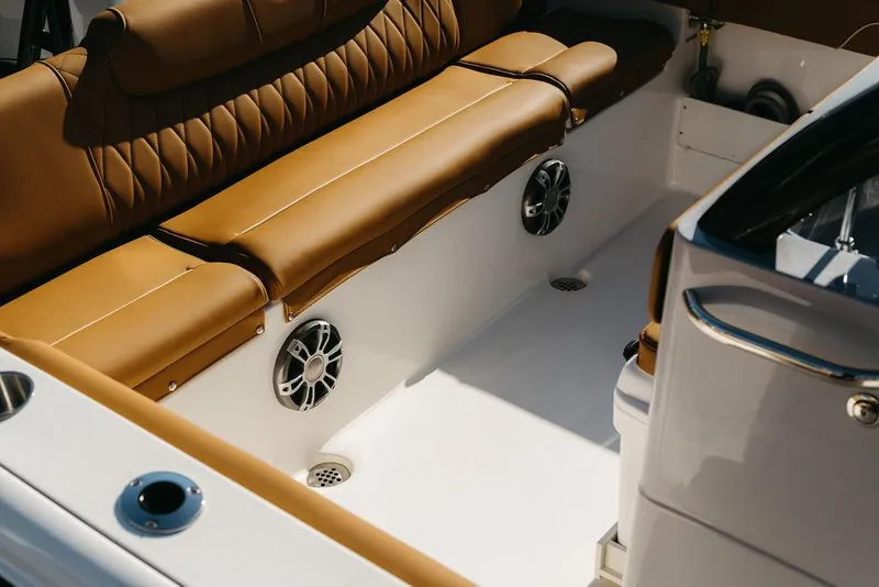 Slide: The Image of 2025 Key West 239FSR boat interior with tan leather seating and built-in speakers. - 15