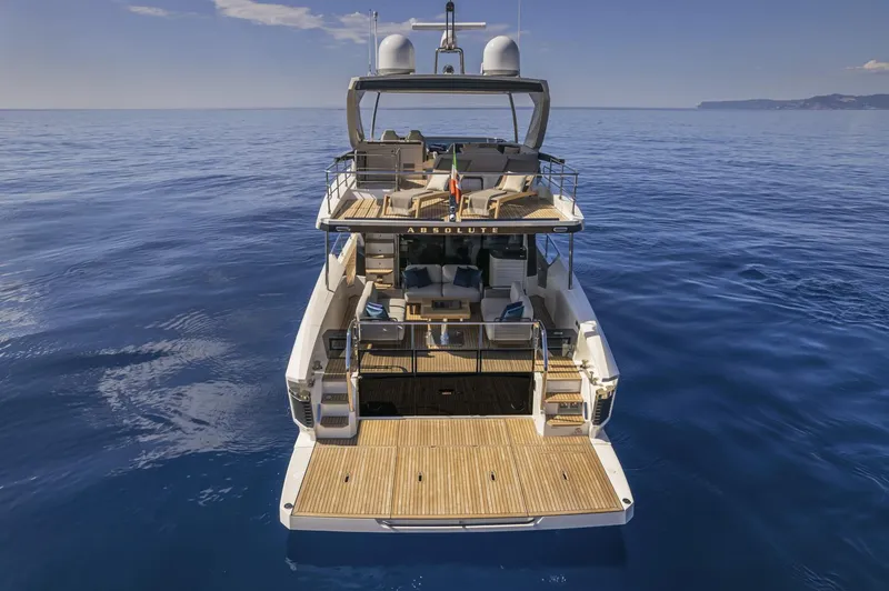 Slide: The Image of 2025 Absolute 60 Fly Co Ownership yacht on calm ocean waters, rear view. - 4