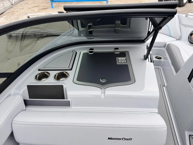 Slide: The Image of 2022 MasterCraft XT21 boat interior with sleek design, cup holders, and storage compartment. - 17