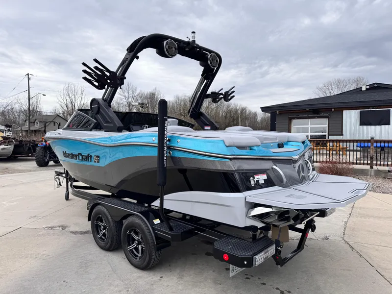 Slide: The Image of 2022 MasterCraft XT21 boat on trailer, featuring sleek design and vibrant blue accents. - 2