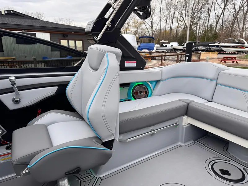 Slide: The Image of 2022 MasterCraft XT21 boat interior with gray seating and blue accents. - 20