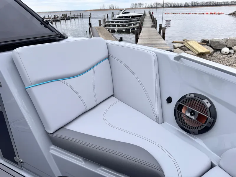 Slide: The Image of 2022 MasterCraft XT21 boat interior with sleek seating and speaker, dockside view. - 21