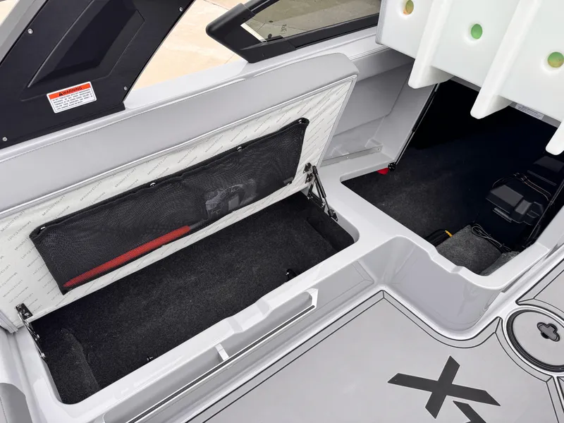 Slide: The Image of 2022 MasterCraft XT21 boat interior storage compartments with netting and open spaces. - 25