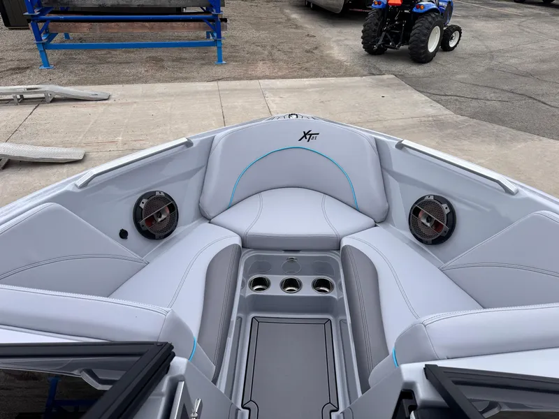 Slide: The Image of 2022 MasterCraft XT21 boat interior with gray seating and built-in speakers. - 9
