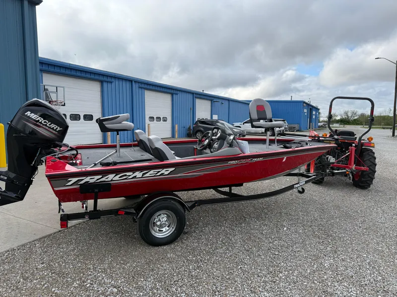 Slide: The Image of 2016 Tracker Pro Team 175 TXW boat with Mercury engine, parked outside blue building. - 3