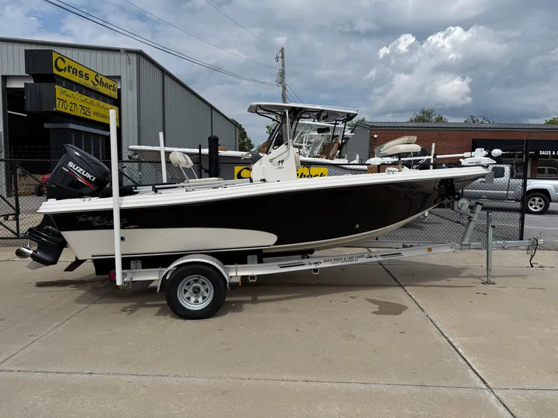 Slide: The Image of 2015 Carolina Skiff 19 Sea Skiff boat on trailer, parked outdoors. - 2