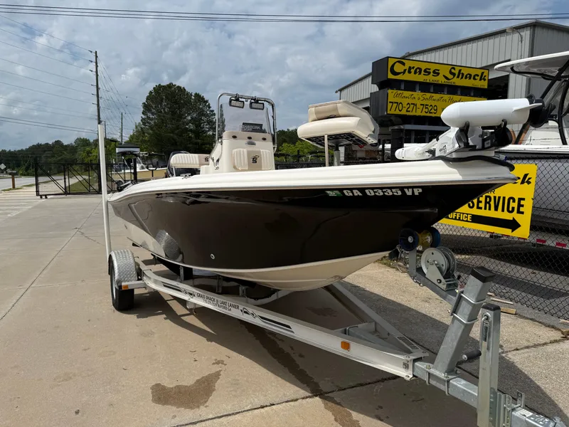 Slide: The Image of 2015 Carolina Skiff 19 Sea Skiff on trailer, parked outdoors near a service shop. - 3