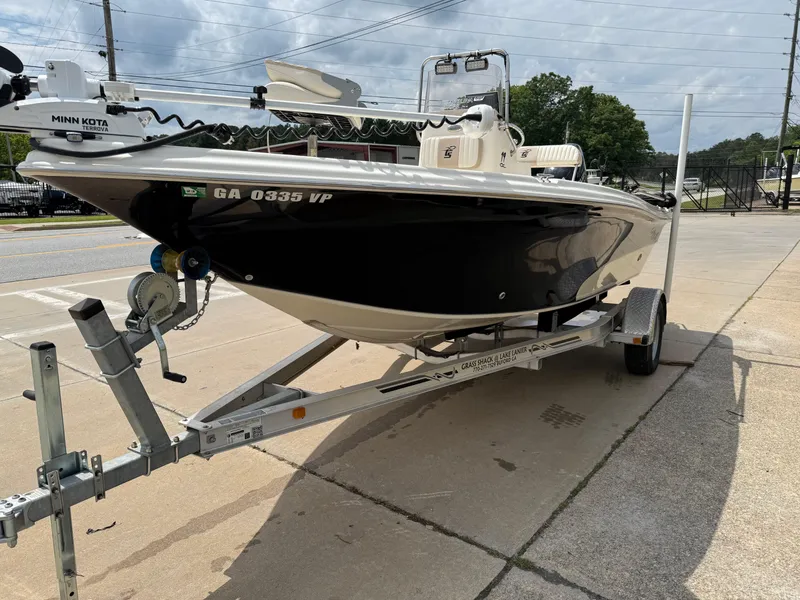 Slide: The Image of 2015 Carolina Skiff 19 Sea Skiff on trailer, parked outdoors, featuring Minn Kota trolling motor. - 6