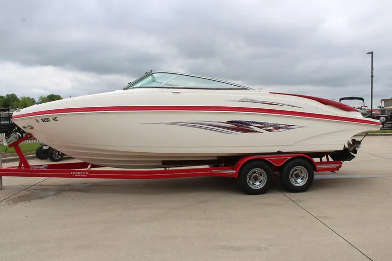 Slide: The Image of 2007 Rinker 246 Captiva Bowrider on red trailer, parked outdoors under cloudy sky. - 11