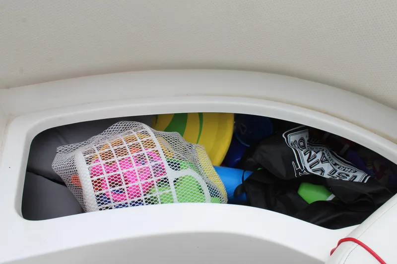 Slide: The Image of Storage compartment in 2007 Rinker 246 Captiva Bowrider filled with colorful boating accessories. - 21