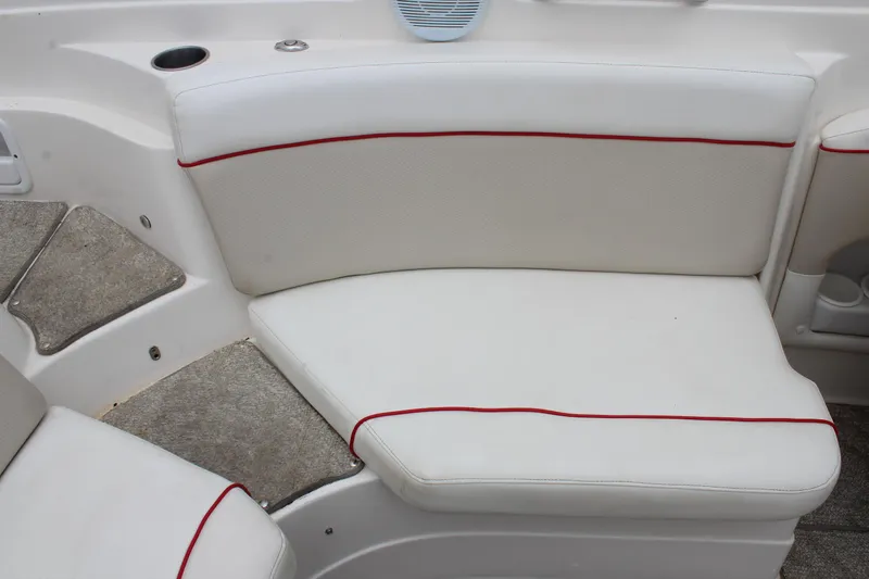 Slide: The Image of 2007 Rinker 246 Captiva Bowrider interior seating with white upholstery and red trim. - 22