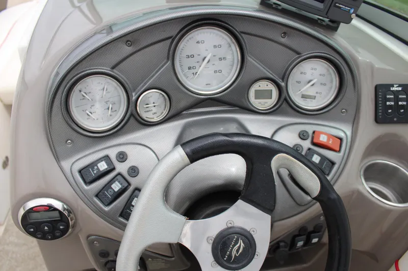 Slide: The Image of Dashboard of a 2007 Rinker 246 Captiva Bowrider boat with gauges and steering wheel. - 26