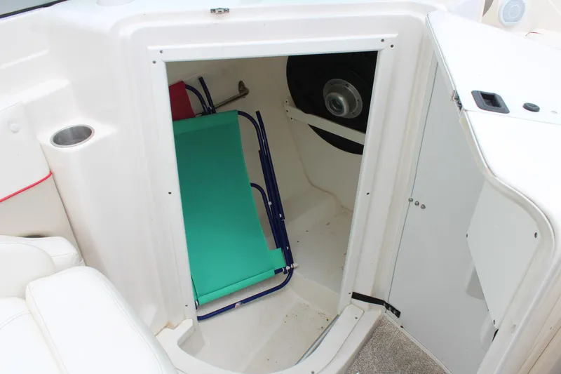 Slide: The Image of 2007 Rinker 246 Captiva Bowrider storage compartment with a folded chair inside. - 27