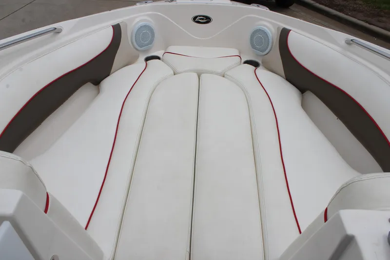 Slide: The Image of 2007 Rinker 246 Captiva Bowrider interior with white and red seating, featuring built-in speakers. - 30