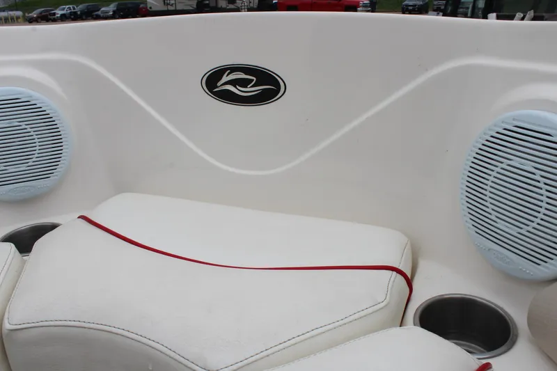 Slide: The Image of 2007 Rinker 246 Captiva Bowrider interior with white seating, red trim, and built-in speakers. - 32