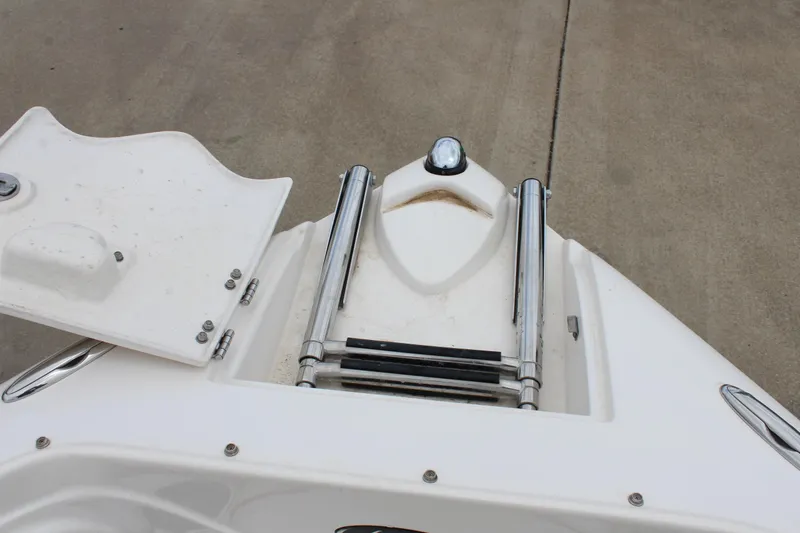 Slide: The Image of 2007 Rinker 246 Captiva Bowrider boat ladder and hatch on concrete surface. - 33
