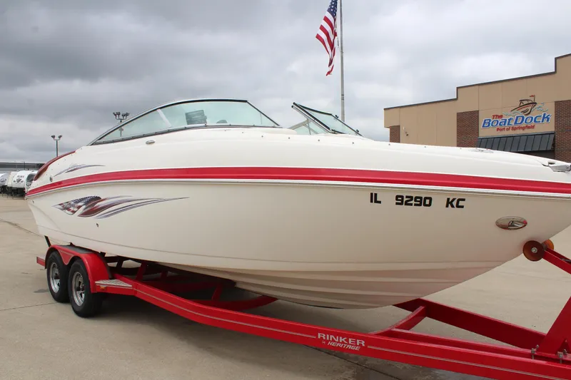 Slide: The Image of 2007 Rinker 246 Captiva Bowrider on red trailer, parked near a boat dock. - 8