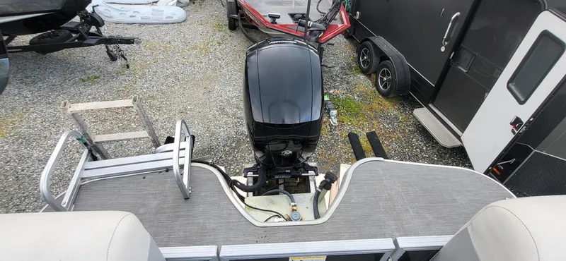 Slide: The Image of 2022 Lowe SS 210 boat with outboard motor, parked on gravel near trailers. - 7