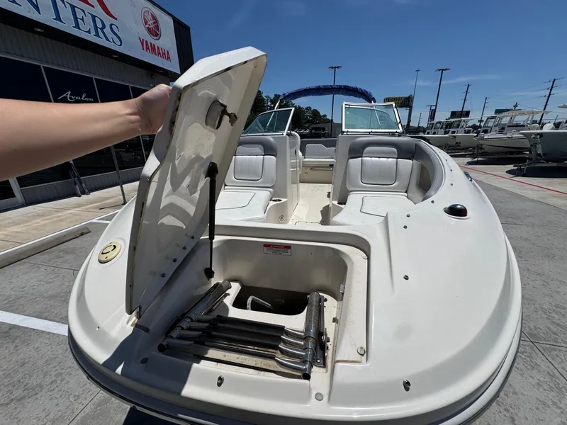 Slide: The Image of 2010 Sea Ray 220 Sundeck boat with open storage compartment, displayed outdoors. - 10