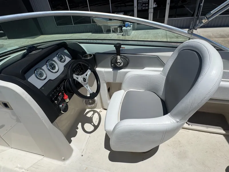 Slide: The Image of Interior of 2010 Sea Ray 220 Sundeck boat, featuring steering wheel and dashboard controls. - 21