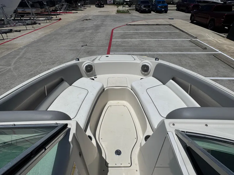 Slide: The Image of 2010 Sea Ray 220 Sundeck boat interior with seating and speakers in a parking lot. - 22